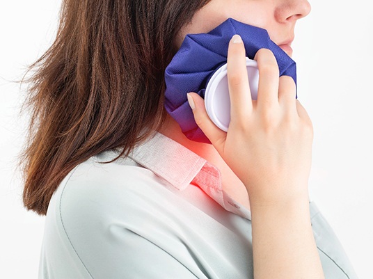 a person using a cold compress after tooth extraction