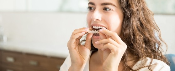 woman putting in invisalign tray