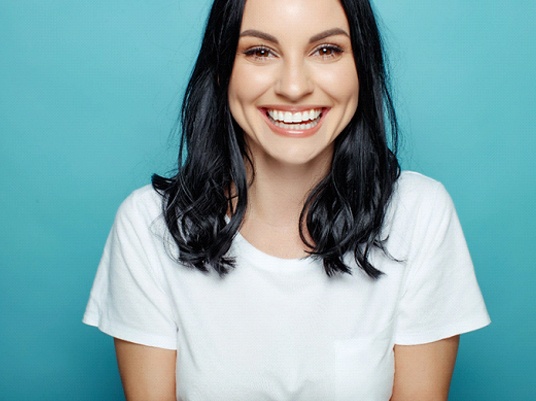 Woman smiling after seeing her cosmetic dentist in Arlington