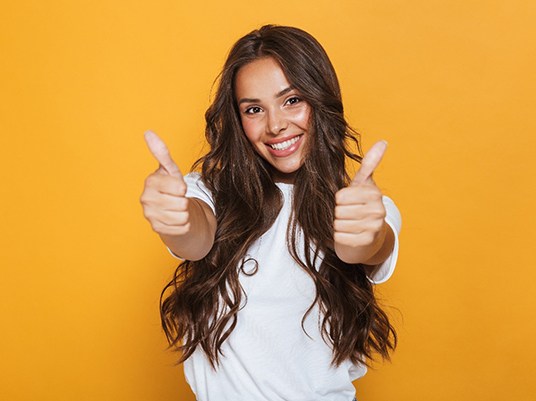 Woman with attractive smile giving thumbs up. 