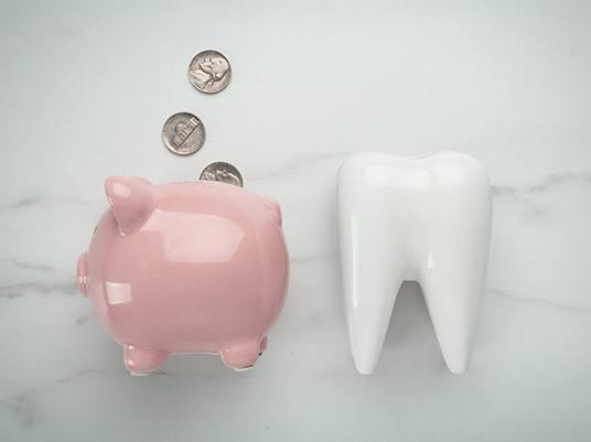 piggy bank and tooth for cost of cosmetic dentistry in Arlington    