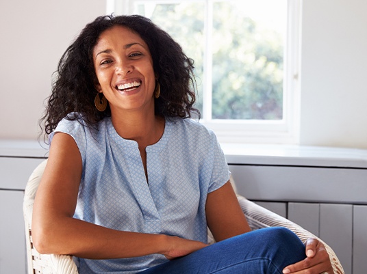 woman smiling in chair at home