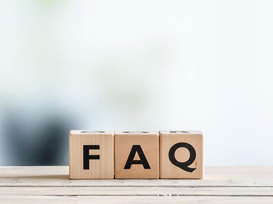 Wooden FAQ letter blocks on ledge with white background 