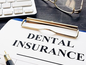 Dental insurance paperwork on clipboard for the cost of dentures in Arlington 