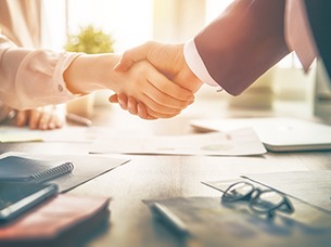 Dentist and patient shaking hands over the cost of dentures in Arlington 