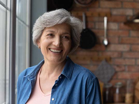 woman smiling after getting dentures in Arlington