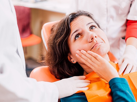 Pained woman with toothache visiting emergency dentist in Arlington