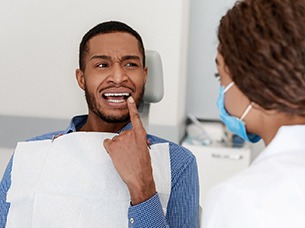 Patient with toothache pointing to his tooth