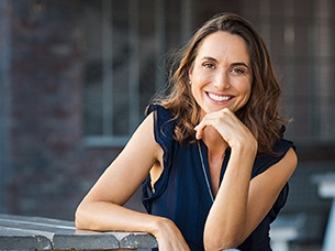 woman smiling with head propped on her hand