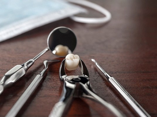 Tooth being held in forceps lying on a table