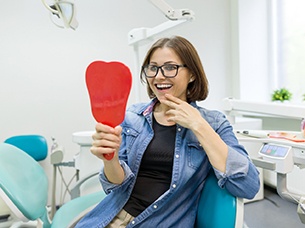 Young woman admiring her new dental implants in Arlington 