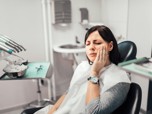 Woman holding cheek in pain