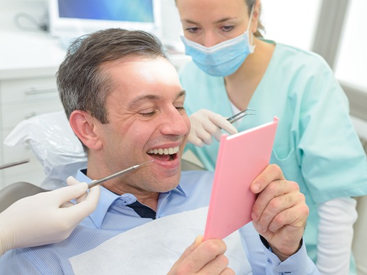 man looking at smile in pink mirror