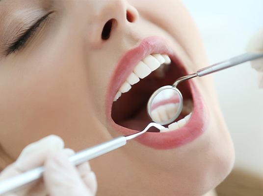 close up of dentist scaling woman's mouth