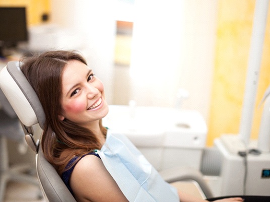 A young woman sitting in a dental chair.