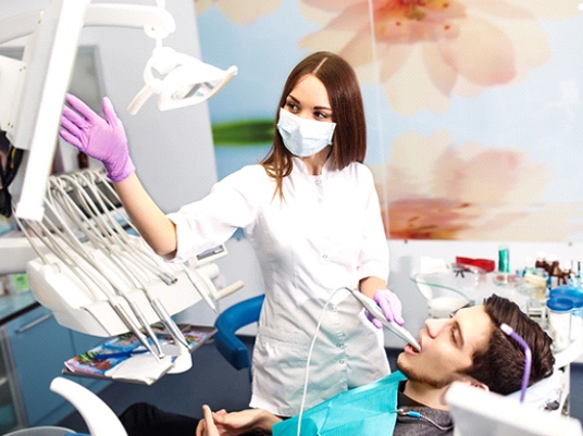 Dentist scanning a patient’s mouth with an intraoral scanner.