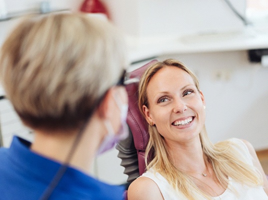 Woman discussing cosmetic dental services near Kennedale with dentist.