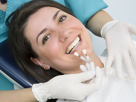 woman with porcelain veneers shades in front of her