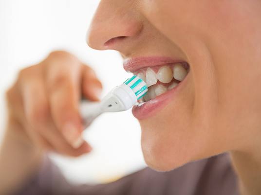 Closeup of woman brushing her teeth