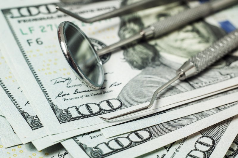 Dental tools lying on pile of money