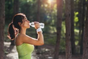 woman drinking water during exercise